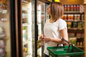 Woman shopping at grocery store frozen food section