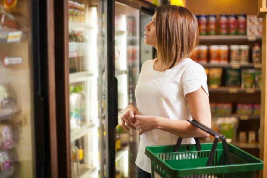 Woman shopping at grocery store frozen food section