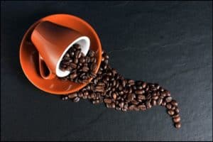Coffee cup with beans spilling out