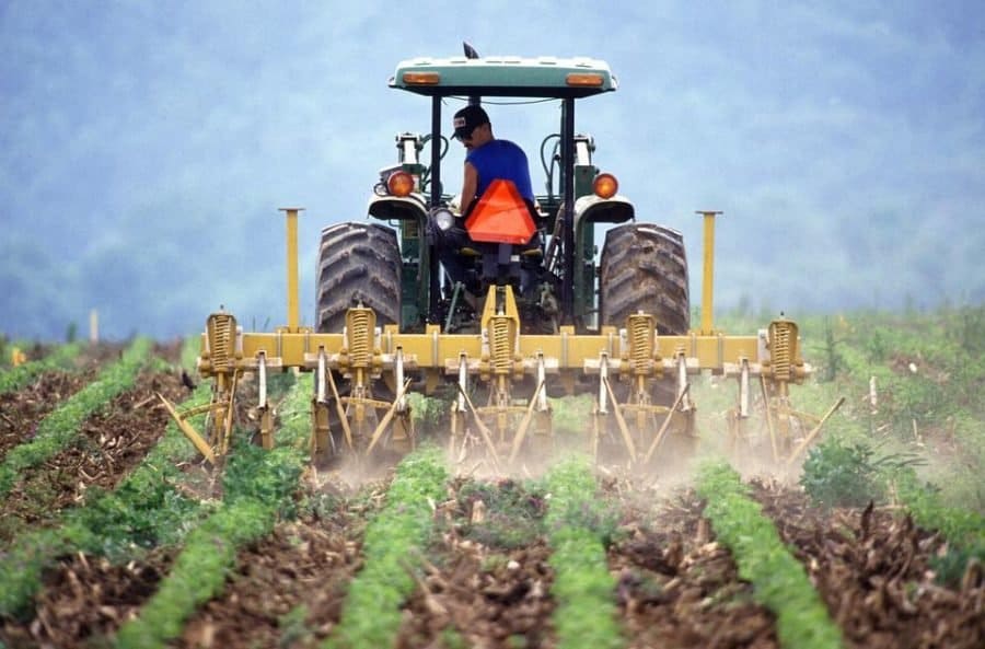 Tractor tilling a field with spoil overturned