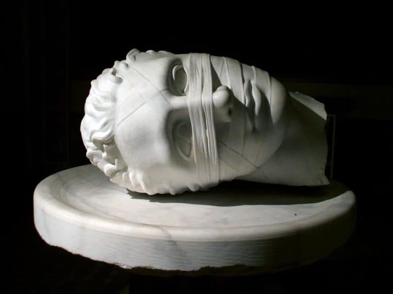 Marble statue of a human head looking depressed. Credit Pixabay.