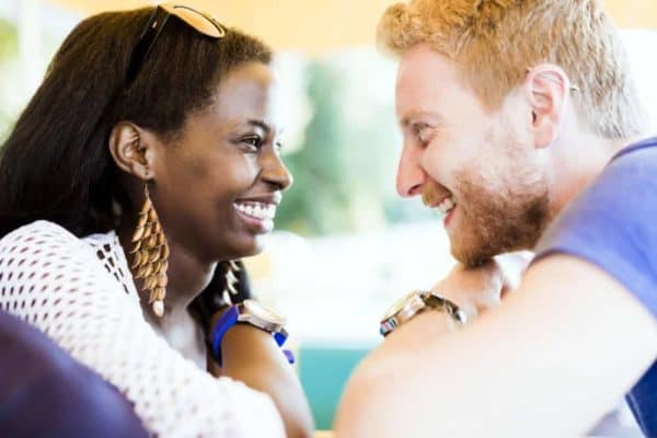 Romantic couple smiling while looking into each others eyes with love