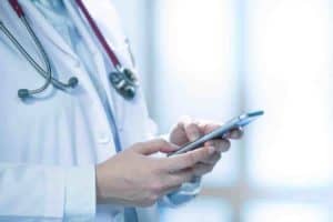 Medical doctor using smart phone for work in hospital