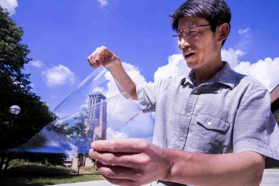 Jay Guo holds a sheet of flexible transparent conductor on the University of Michigan’s College of Engineering North Campus. The material sandwiches a thin layer of silver between two “dielectric” materials, aluminum oxide and zinc oxide, producing a conductive anti-reflection coating on the sheet of plastic. Image credit: Robert Coelius/University of Michigan Engineering, Communications & Marketing