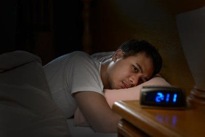 Man trying to fall asleep with insomnia