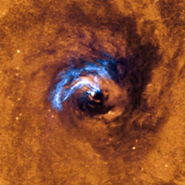 The image shows the process of nuclear feeding of a black hole in the galaxy NGC 1566, and how the dust filaments, which surround the active nucleus, are trapped and rotate in a spiral around the black hole until it swallows them.