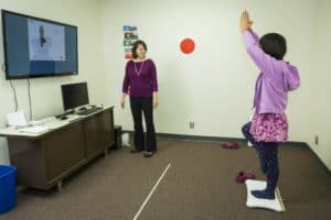 Brittany Travers with a study participant during a training session for a video game that helps improve balance in autistic teenagers. ANDY MANIS