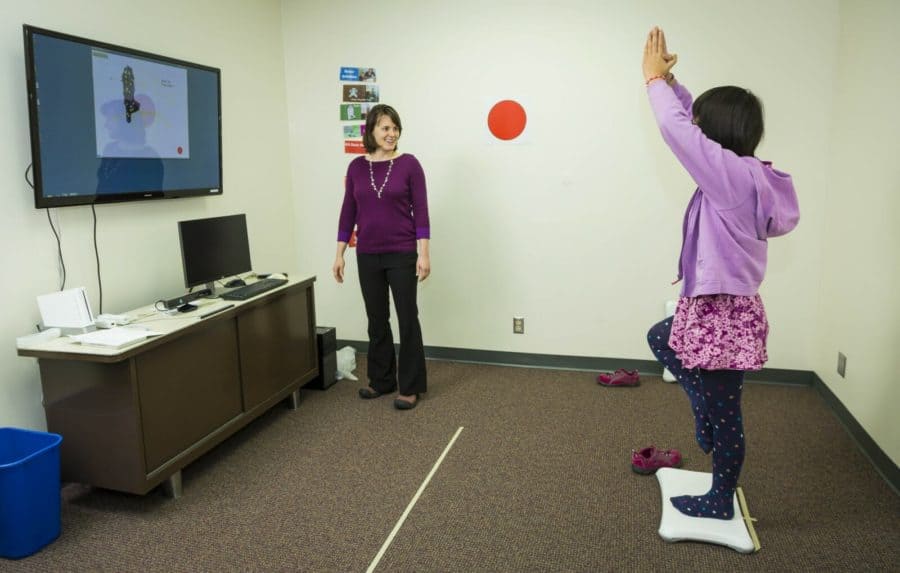 Brittany Travers with a study participant during a training session for a video game that helps improve balance in autistic teenagers. ANDY MANIS