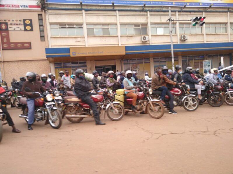 Motorcycle taxis, known as boda bodas, wait on the side of the road in Kampala, Uganda.