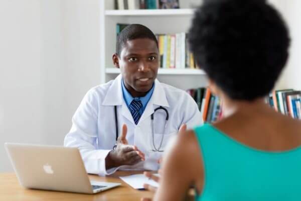 Black physician speaking with female patient