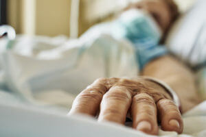 Senior woman wearing face mask lying on hospital bed Credit: RUBEN BONILLA GONZALO