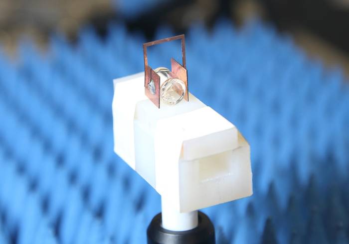 Copper “headphones” boost the sensitivity of NIST’s atomic radio receiver, which is composed of a gas of cesium atoms prepared in a special state inside the glass container. When an antenna located above the setup sends down a radio signal, the headphones boost the strength of the received signal a hundredfold.