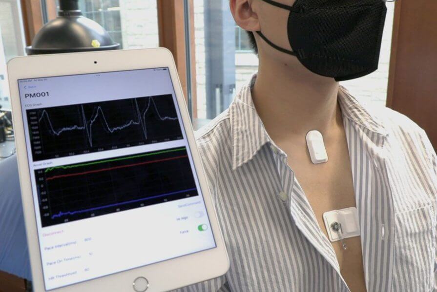 A tablet shows an electrocardiogram, recorded by a network of soft, wireless, wearable sensors.