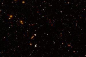 This image captured by the Hubble Space Telescope shows a region of about 5,000 galaxies located billions of light-years away. The region is located within a cosmic field called the Extended Groth Strip, one of five well-studied fields that were observed in a program called CANDELS, for Cosmic Assembly Near-infrared Deep Extragalactic Legacy Survey. In this new view, taken as part of a program called UVCANDELS, ultraviolet and blue optical light have been added into the imagery, in addition to the optical and infrared light observed previously. Ultraviolet light and blue optical light are shown in blue; red light appears green; and near-infrared light is red. The region pictured covers 9 square arcminutes, which is the equivalent of about one percent the size of the full moon on the sky.