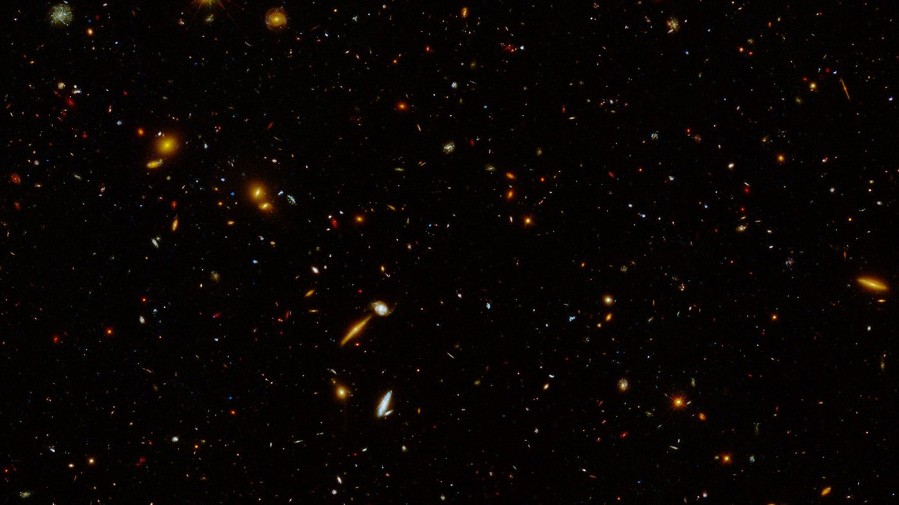 This image captured by the Hubble Space Telescope shows a region of about 5,000 galaxies located billions of light-years away. The region is located within a cosmic field called the Extended Groth Strip, one of five well-studied fields that were observed in a program called CANDELS, for Cosmic Assembly Near-infrared Deep Extragalactic Legacy Survey. In this new view, taken as part of a program called UVCANDELS, ultraviolet and blue optical light have been added into the imagery, in addition to the optical and infrared light observed previously. Ultraviolet light and blue optical light are shown in blue; red light appears green; and near-infrared light is red. The region pictured covers 9 square arcminutes, which is the equivalent of about one percent the size of the full moon on the sky.