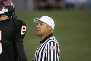 Tall football player with referee.