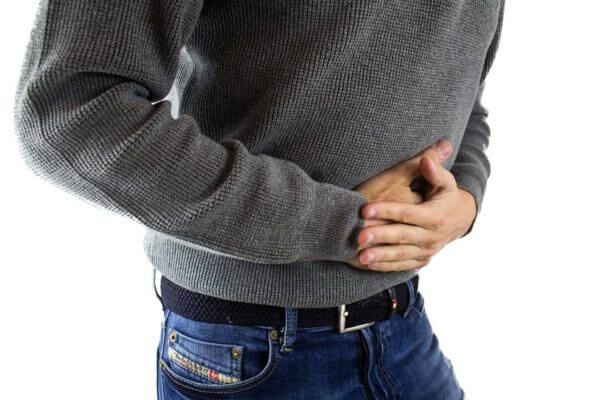 Man clutches stomach in pain
