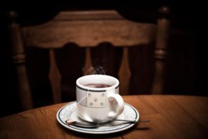 Cup of black tea on a wooden dining room table