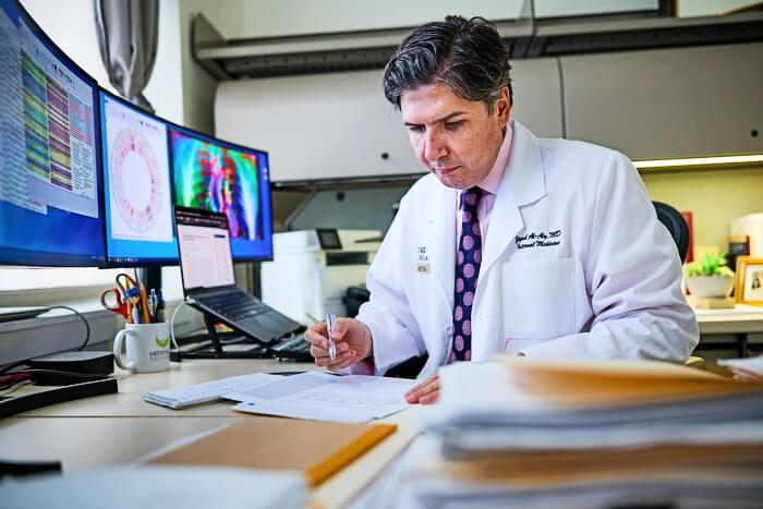 Ziyad Al-Aly, MD, a clinical epidemiologist at Washington University School of Medicine in St. Louis and the Veterans Affairs St. Louis Health Care system, examines data from a new study. Researchers led by Al-Aly found that repeat SARS-CoV-2 infections contribute significant additional risk of adverse health conditions in multiple organ systems.