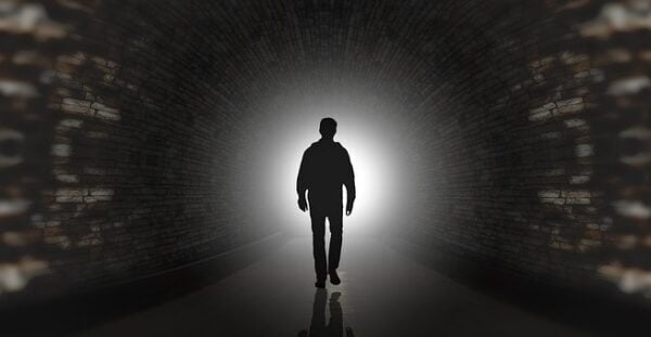 Conspiracy illustration of a man in shadows in a long tunnel