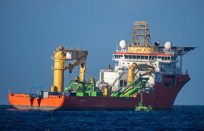 A view of the Normand Energy deploying the Patania II nodule collector visible (green), seen from the Rainbow Warrior. The vessel is chartered by Global Sea Mineral Resources (GSR), a Belgian company researching deep sea mining in the Pacific. The company is currently testing mining gear with the aim of future commercial extraction of minerals from the seabed.