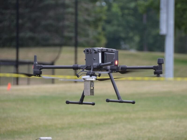 A drone used to detect radiation hovers near the tennis courts at the intermural fields on West Campus at University Park during the drone demonstration July 12, 2022, at the 2022 Interaction of Ionizing Radiation with Matter Technical Review. Credit: Jamie Oberdick/Materials Research Institute . All Rights Reserved.