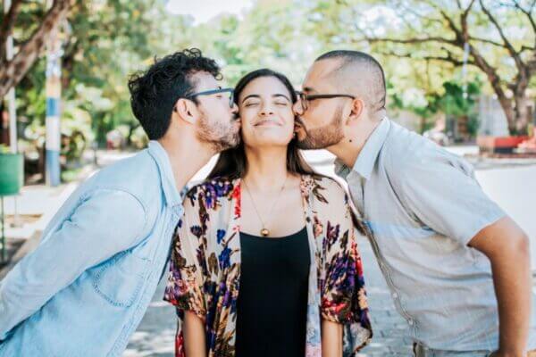 Two men kissing a woman