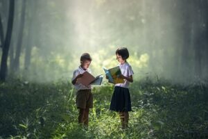 Two children reading in the woods