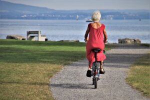 Older woman riding a bicycle, seen from behind