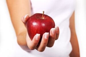 Woman's hand holding a red apple