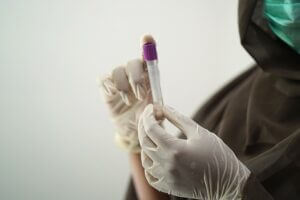 Person holding test tube with blood. Credit Pixabay.