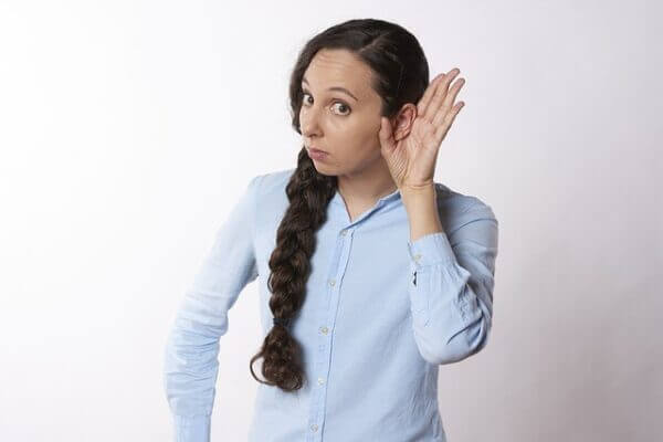 Woman cupping her left ear