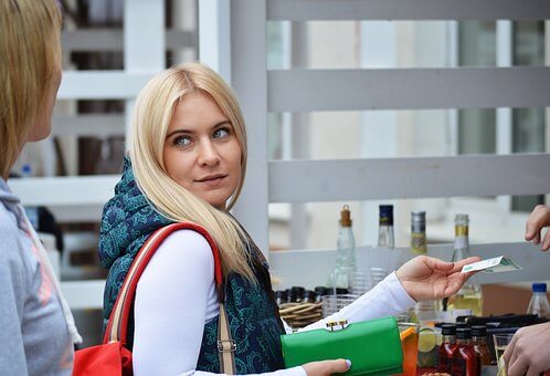Blonde woman handing over credit card at store