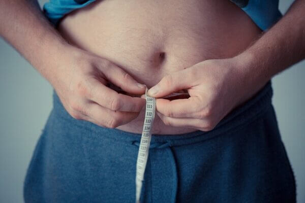 Man with tape measure around waist