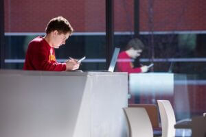 A student looks at his phone in the Student Innovation Center at Iowa State University.
