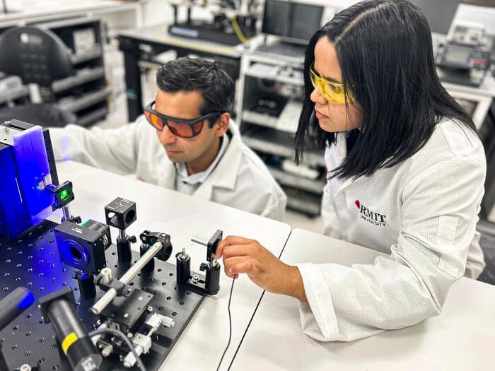 Prof Sumeet Walia (left) and PhD researcher Aishani Mazumder with a demonstration (using visible light) of the experimental set up for the research that used ultraviolet light.