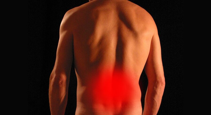 Red spot on man's lower back indicating pain in that location. Pixabay