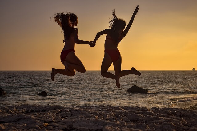 Teen girls jumping in the air seen in silhouette. Credit Pixabay