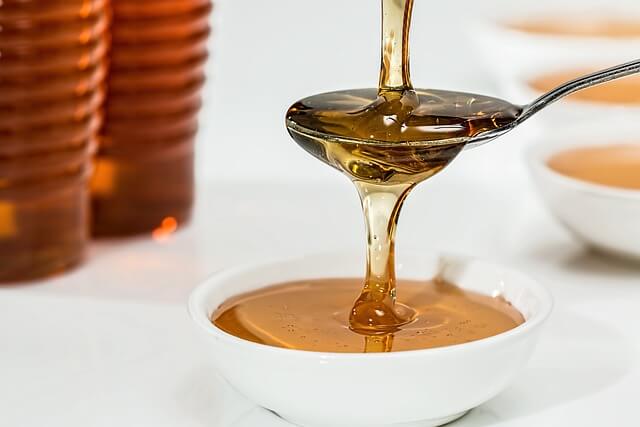 Honey dipper dripping honey. Pixabay