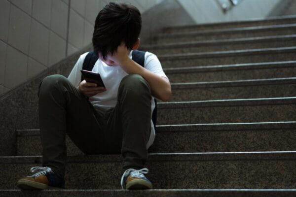 Boy looking stressed as he looks at his phone