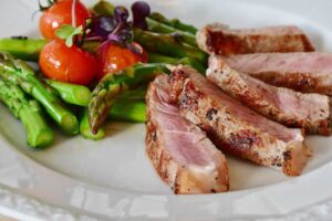 BBQ meat on a plate with asparagus. Pixabay