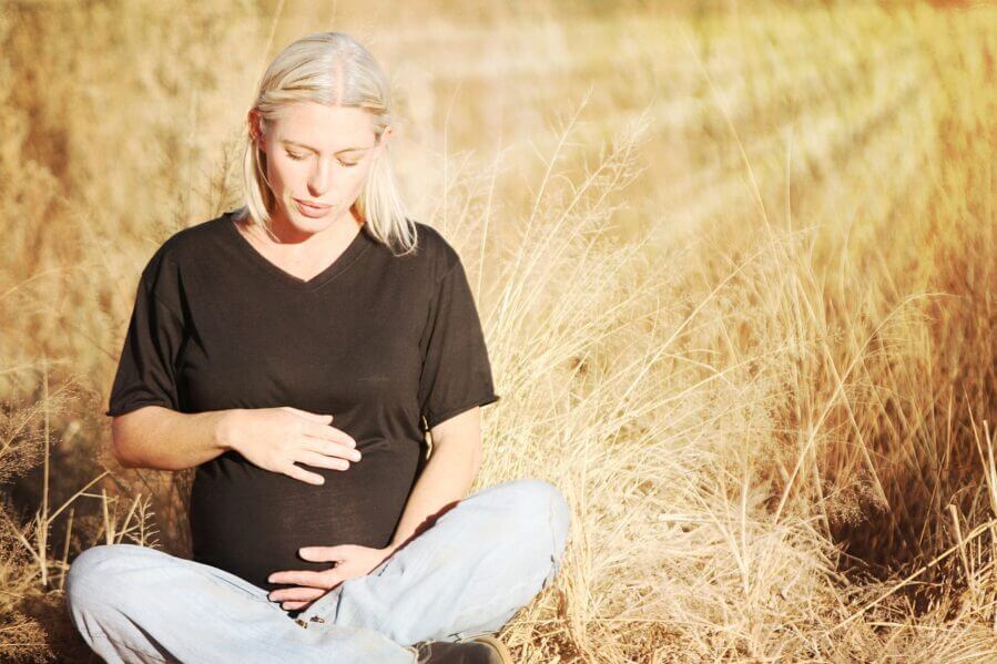 Pregnant woman sitting in a wheat field. Pixabay