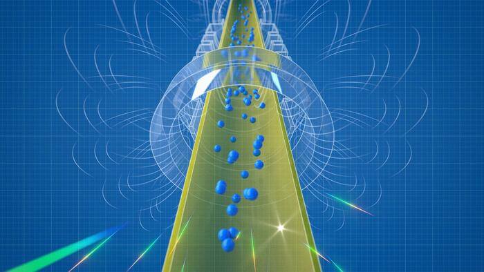 An artist's conceptual rendering of antihydrogen atoms falling out the bottom of the magnetic trap of the ALPHA-g apparatus. As the antihydrogen atoms escape, they touch the chamber walls and annihilate. Most of the annihilations occur beneath the chamber, showing that gravity is pulling the antihydrogen down. The rotating magnetic field lines in the animation represent the invisible influence of the magnetic field on the antihydrogen. The magnetic field does not rotate in the actual experiment.