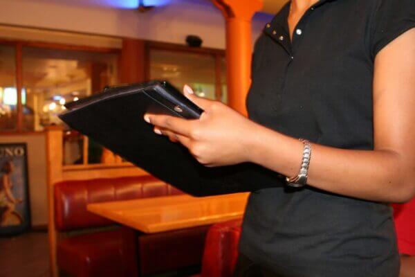 Waitress holding a menu. Pixabay