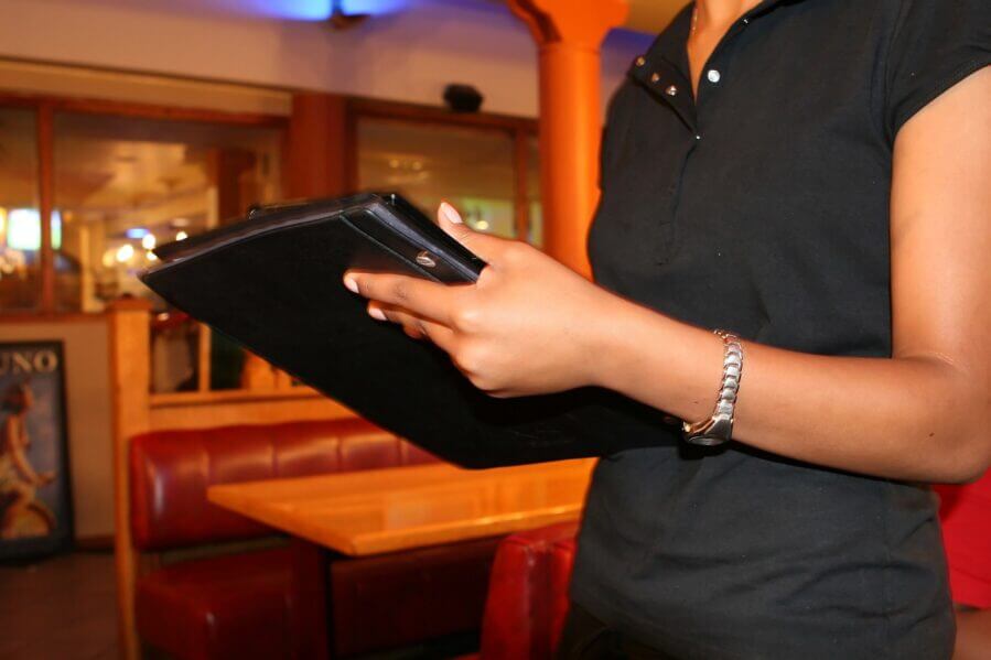 Waitress holding a menu. Pixabay