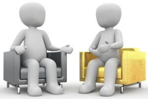 Two figures in chairs having a conversation. Pixabay