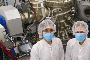 Graduate student Emine Bakali (left) and her supervisor Silke Paschen of TU Wien in front of the molecular beam epitaxy chamber of TU Wien’s clean room that was used for the growth of the YbRh2Si2 thin films. (Photo by Maxwell Andrews/TU Wien)