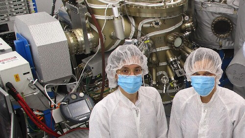 Graduate student Emine Bakali (left) and her supervisor Silke Paschen of TU Wien in front of the molecular beam epitaxy chamber of TU Wien’s clean room that was used for the growth of the YbRh2Si2 thin films. (Photo by Maxwell Andrews/TU Wien)