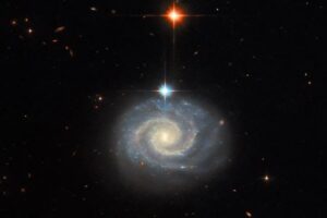 This NASA Hubble Space Telescope image features a bright spiral galaxy known as MCG-01-24-014, which is located about 275 million light-years from Earth.