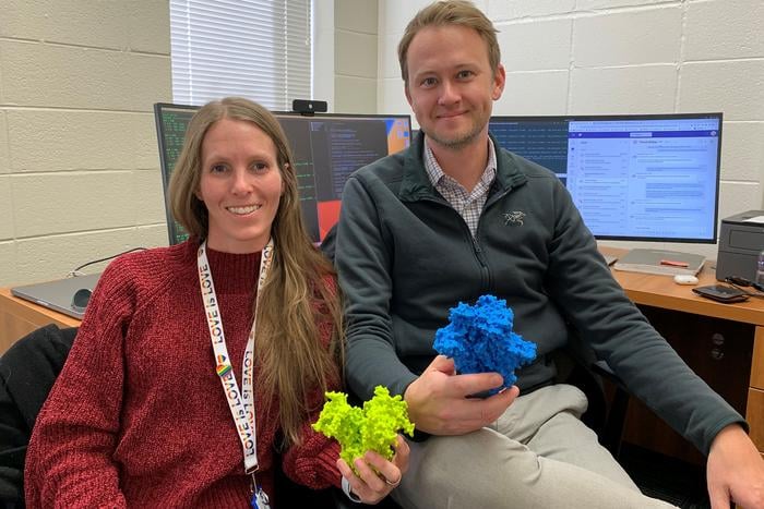 Postdoctoral researcher Ashley Bennett (left) and Associate Professor Rory Henderson of the Duke Human Vaccine Institute with 3D printed models of HIV surface proteins.